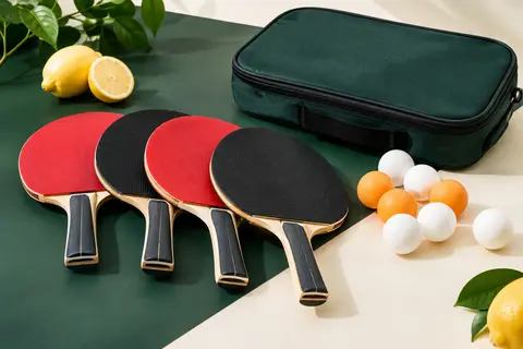 Set de tennis de table avec quatre raquettes en bois, balles blanches et orange et sacoche de rangement