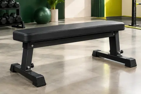 Banc de musculation plat noir avec coussin épais, cadre en acier et pieds réglables.
