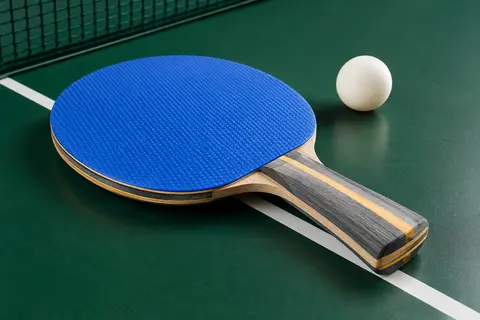 Raquette de tennis de table PRO-SPIN bleue à manche concave, posée sur une table verte