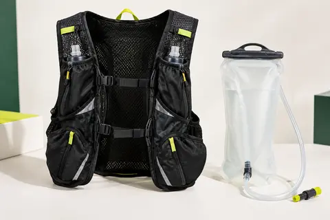 Gilet d’hydratation noir à sangles réglables, accompagné de sa poche à eau et de son tuyau.