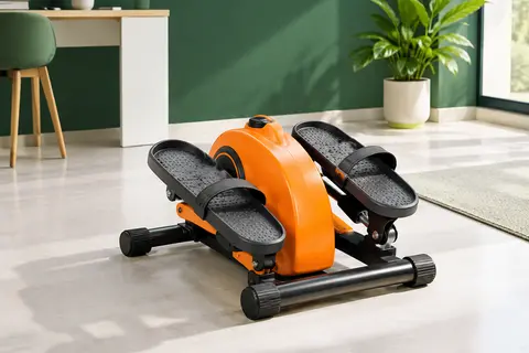 Mini vélo elliptique électrique orange aux pédales texturées, installé près d’un bureau dans un décor sportif sobre.