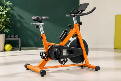 Vélo d’appartement orange à résistance magnétique, avec écran LCD, selle réglable et porte-bouteille.